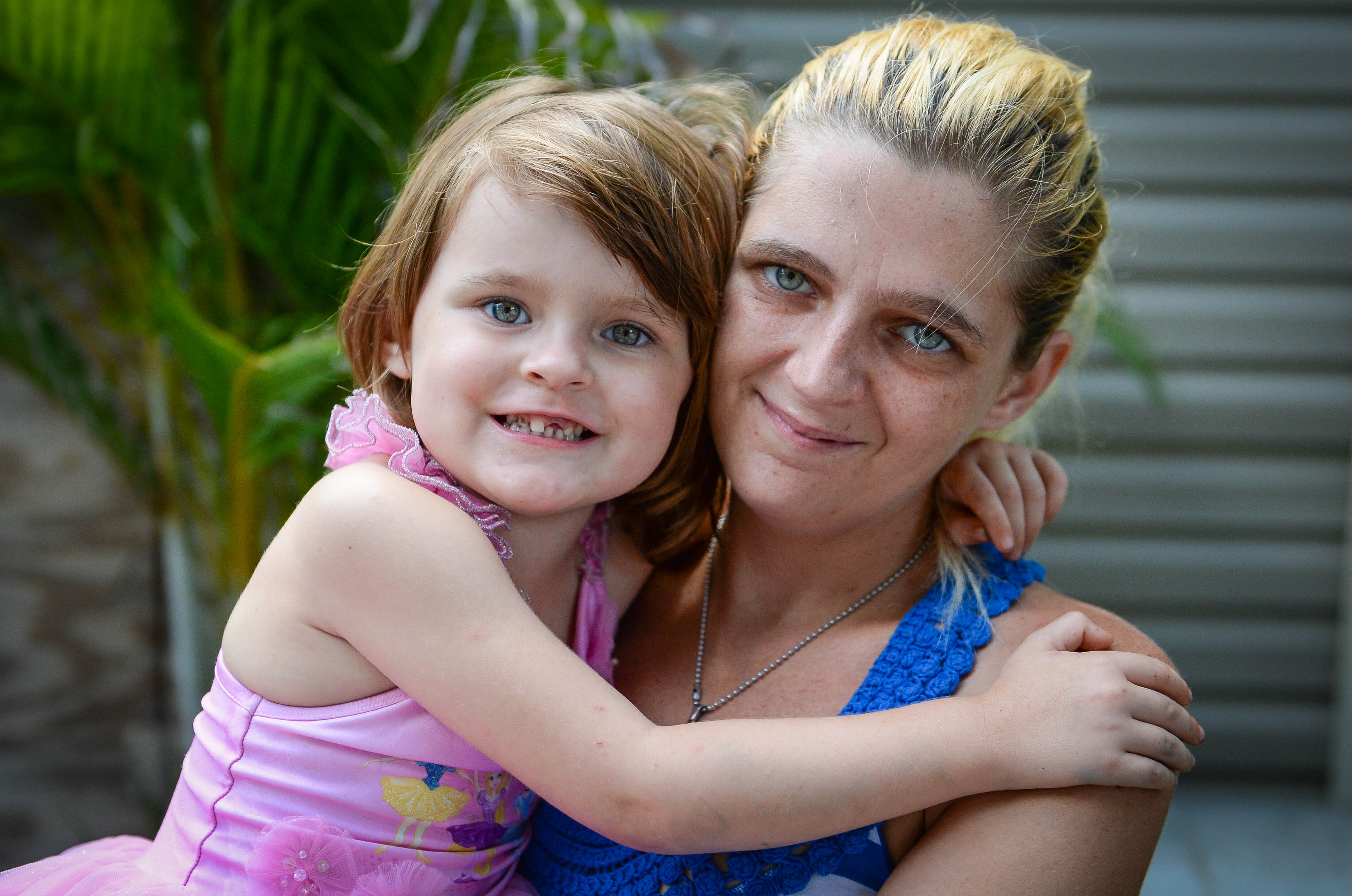 Keriana Carll, 4, and Megan Johnson pose in their yard in Bradenton. Johnson searched for months to find a dentist who was willing to accept Keriana's Medicaid insurance.   STAFF PHOTO / RACHEL S. O'HARA